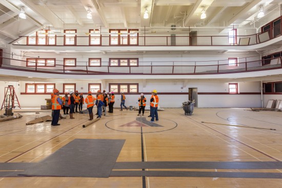 Our tour group marvels at the spaciousness of the light-filled gymnasium at Kelly Cullen Community. (Photo by Oliver Shay)